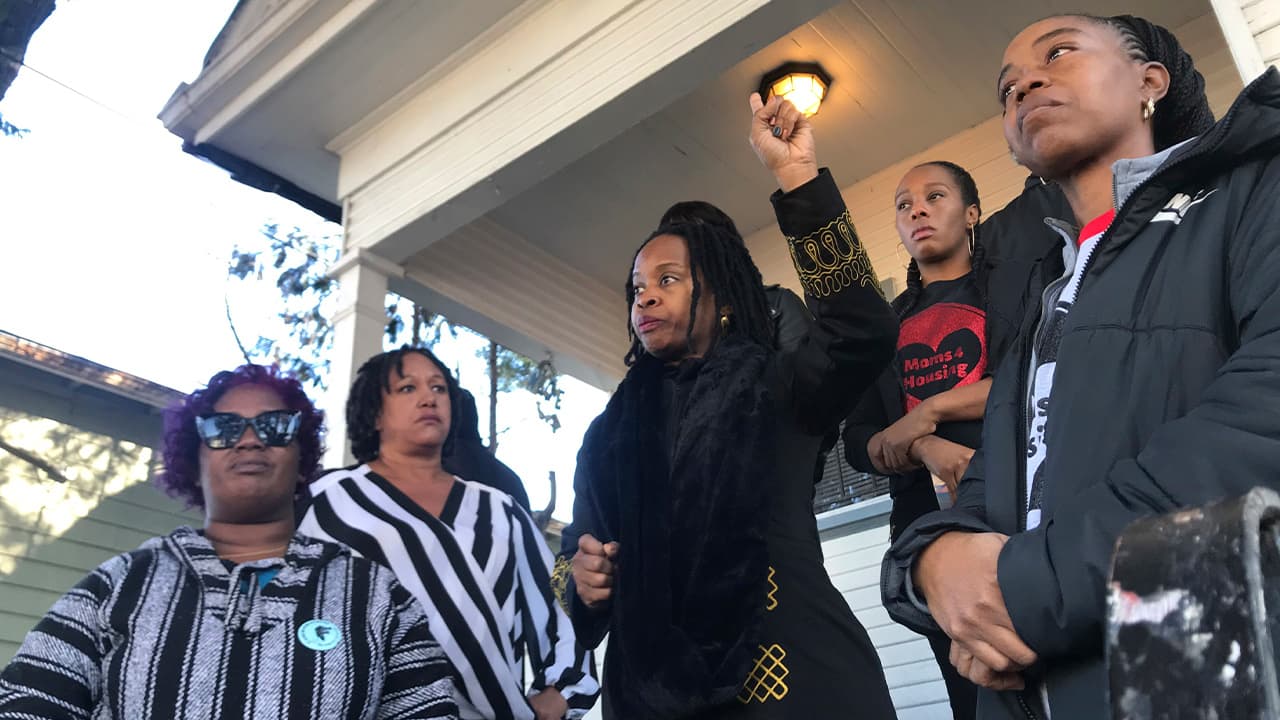 Photo of women standing outside a vacant house in Oakland, Ca.