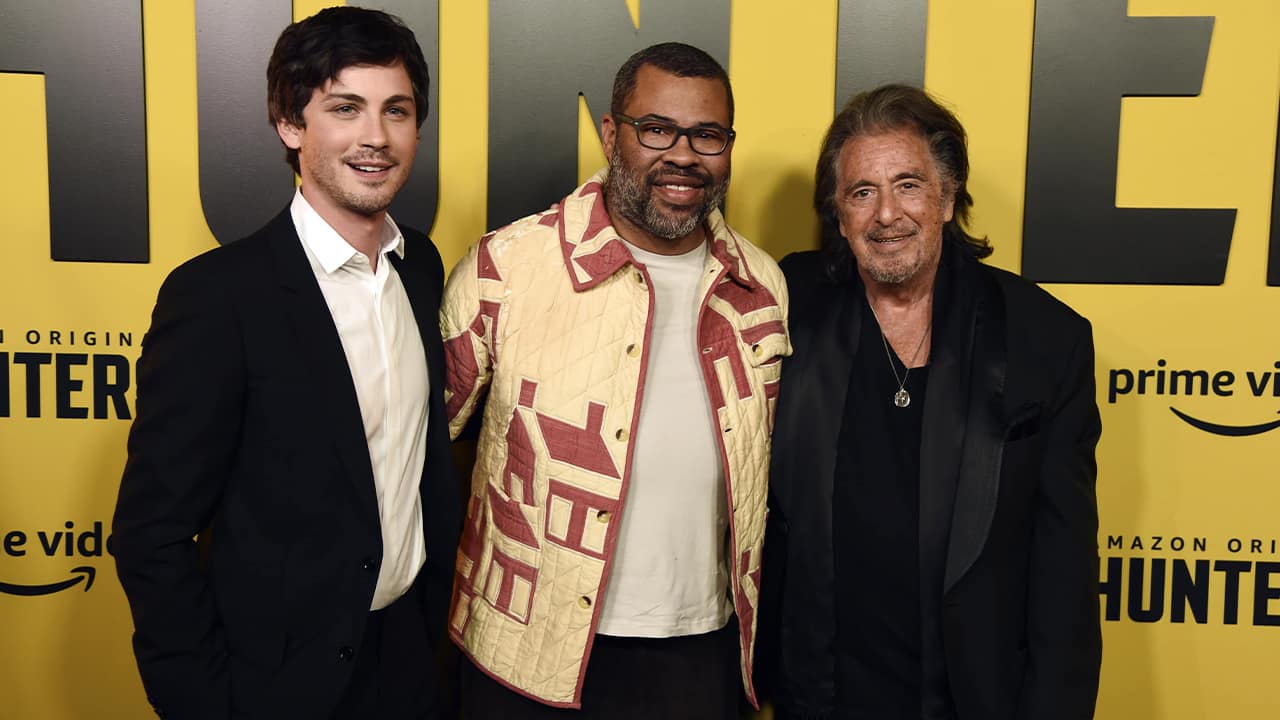 Photo of Jordan Peele, center, executive producer of the Amazon Prime Video series "Hunters," posing with cast members Logan Lerman, left, and Al Pacino