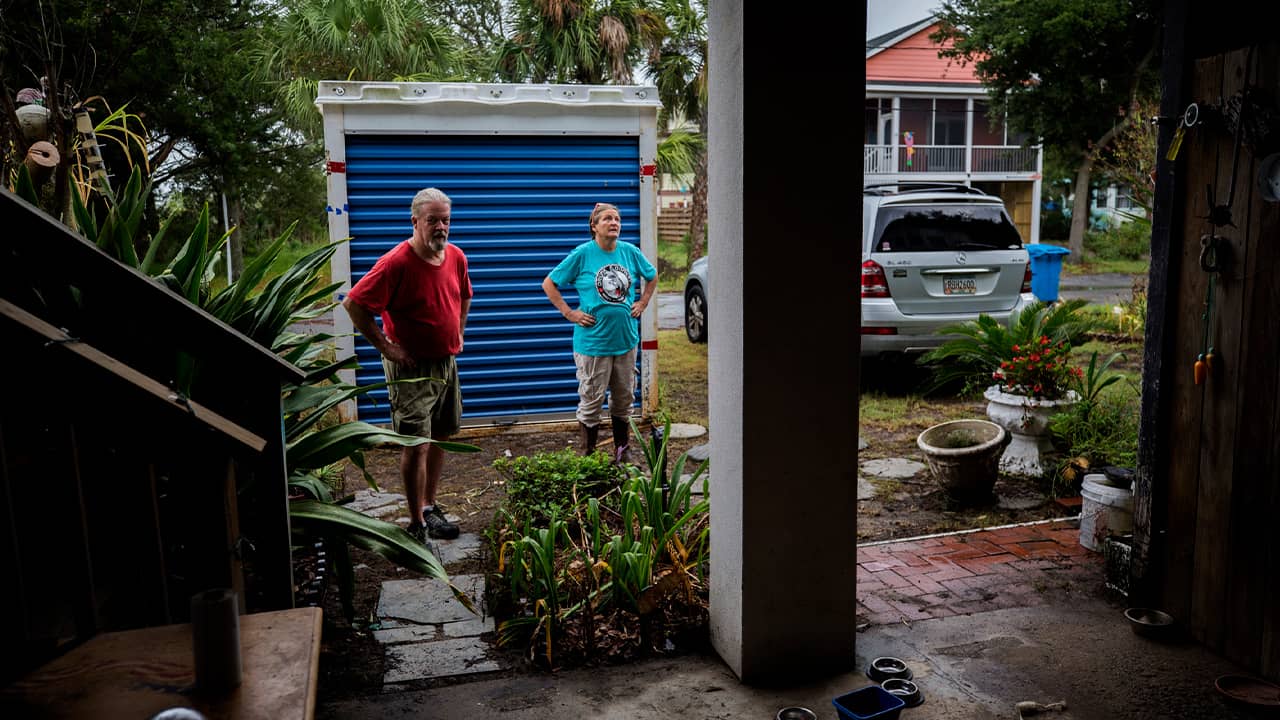 Photo of couple standing outside their home before evacuating