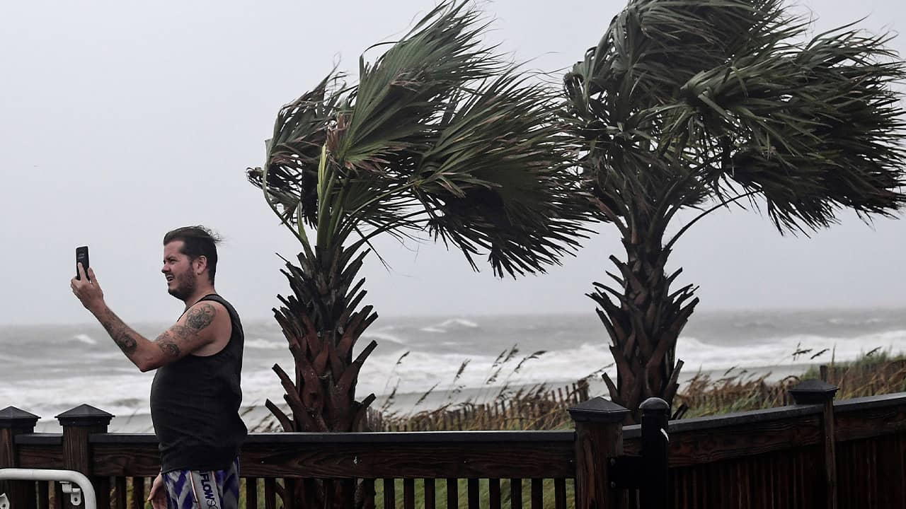 Photo of a man taking photos of waves crashing in Myrtle Beach