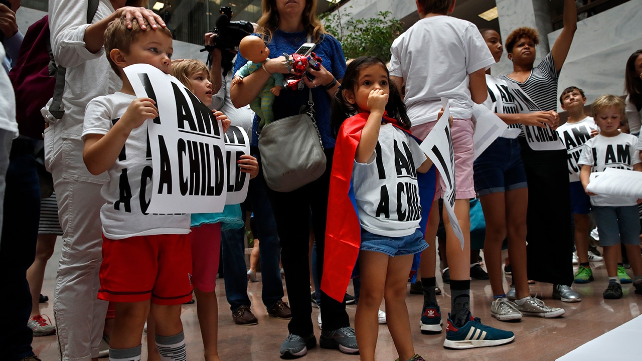 Photo of children and adults at a protest asking for the reunification of immigrant families
