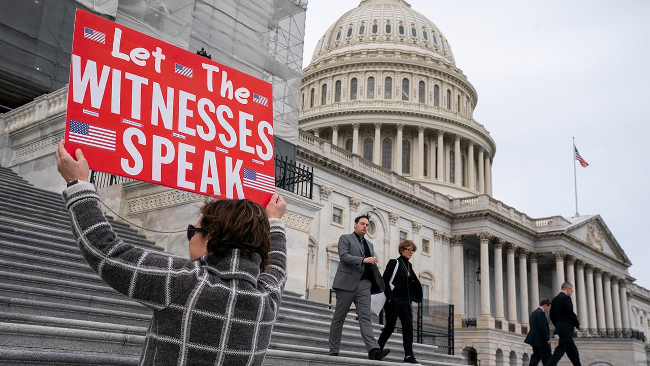 Photo of A woman holding a sign for members of the House