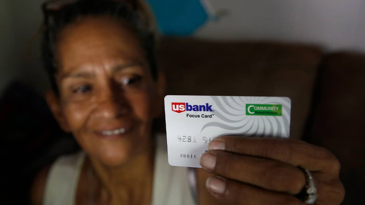 Photo of Susie Garza holding the city provided debit card