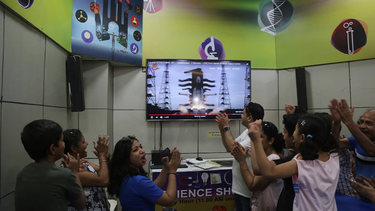 Photo of Indians cheering as they watch the launch on a screen 