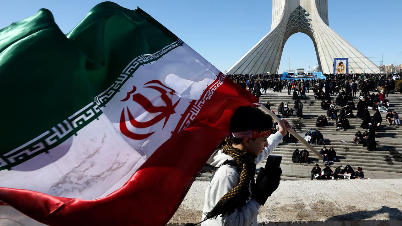 Photo of a boy carrying an Iranian flag