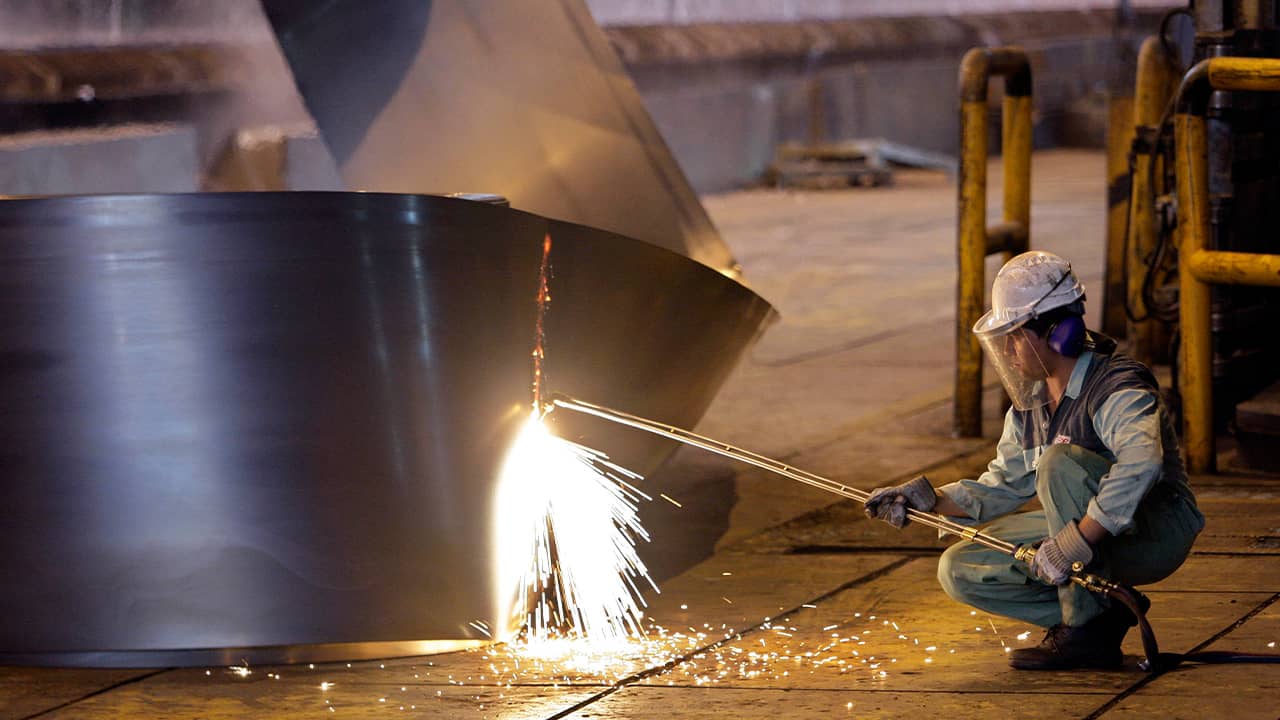 Photo of Iranian worker cutting a steel roll