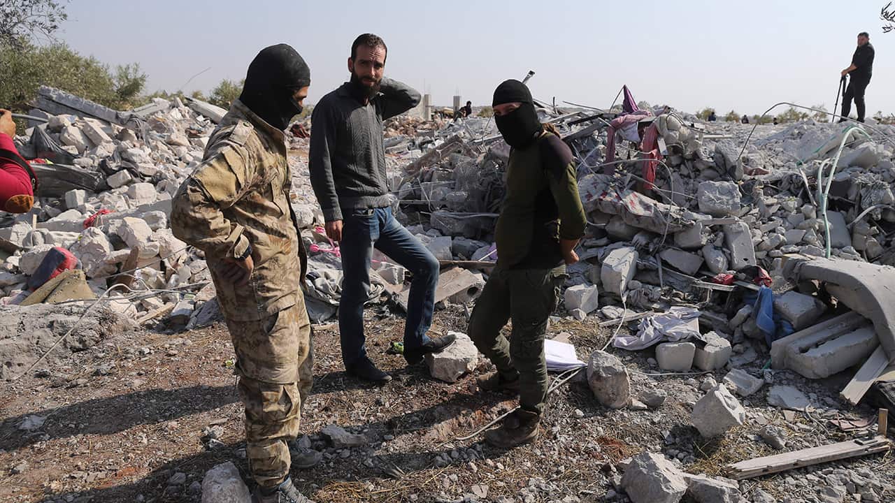 Photo of people looking at destroyed houses