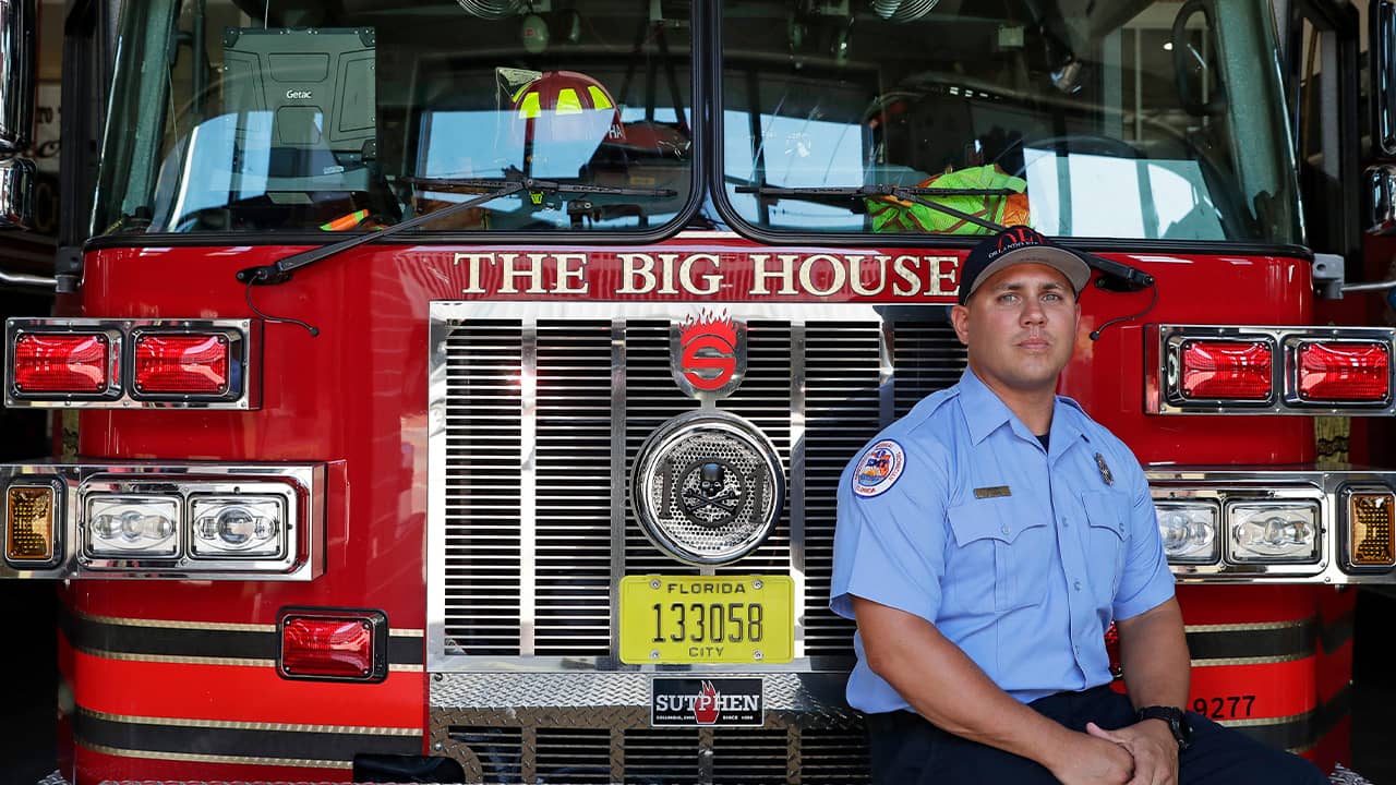 Photo of firefighter Jimmy Reyes next to his firetruck in Orlando, Fla. 