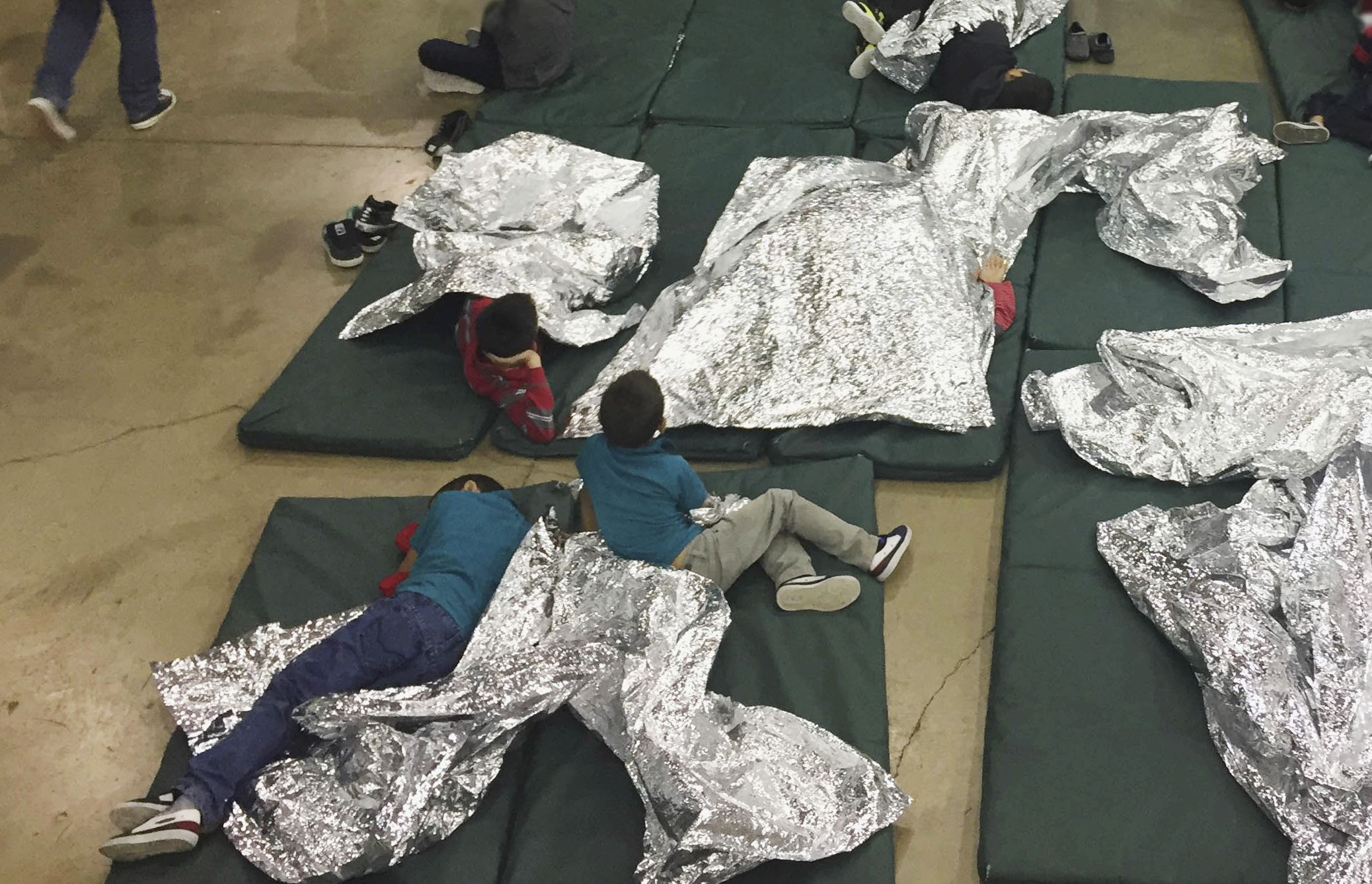 Photo of kids on floor of immigration holding facility in McAllen, Texas