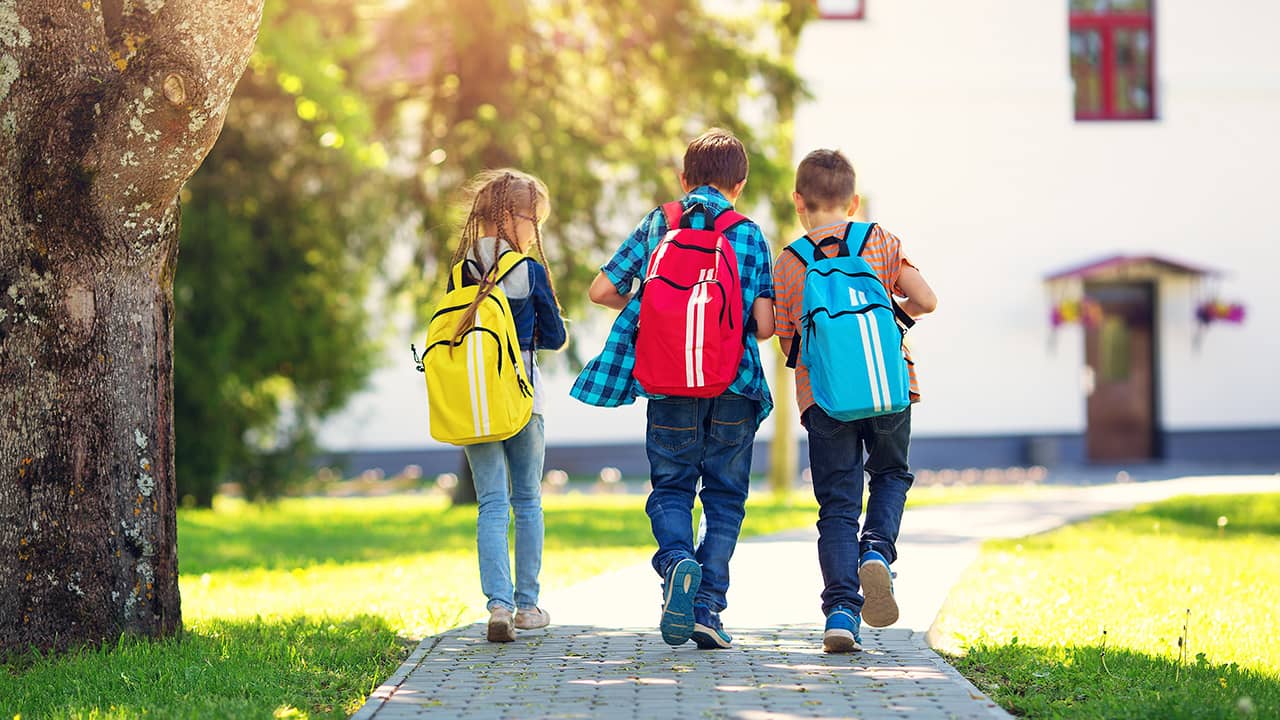 Photo of 3 children walking to school