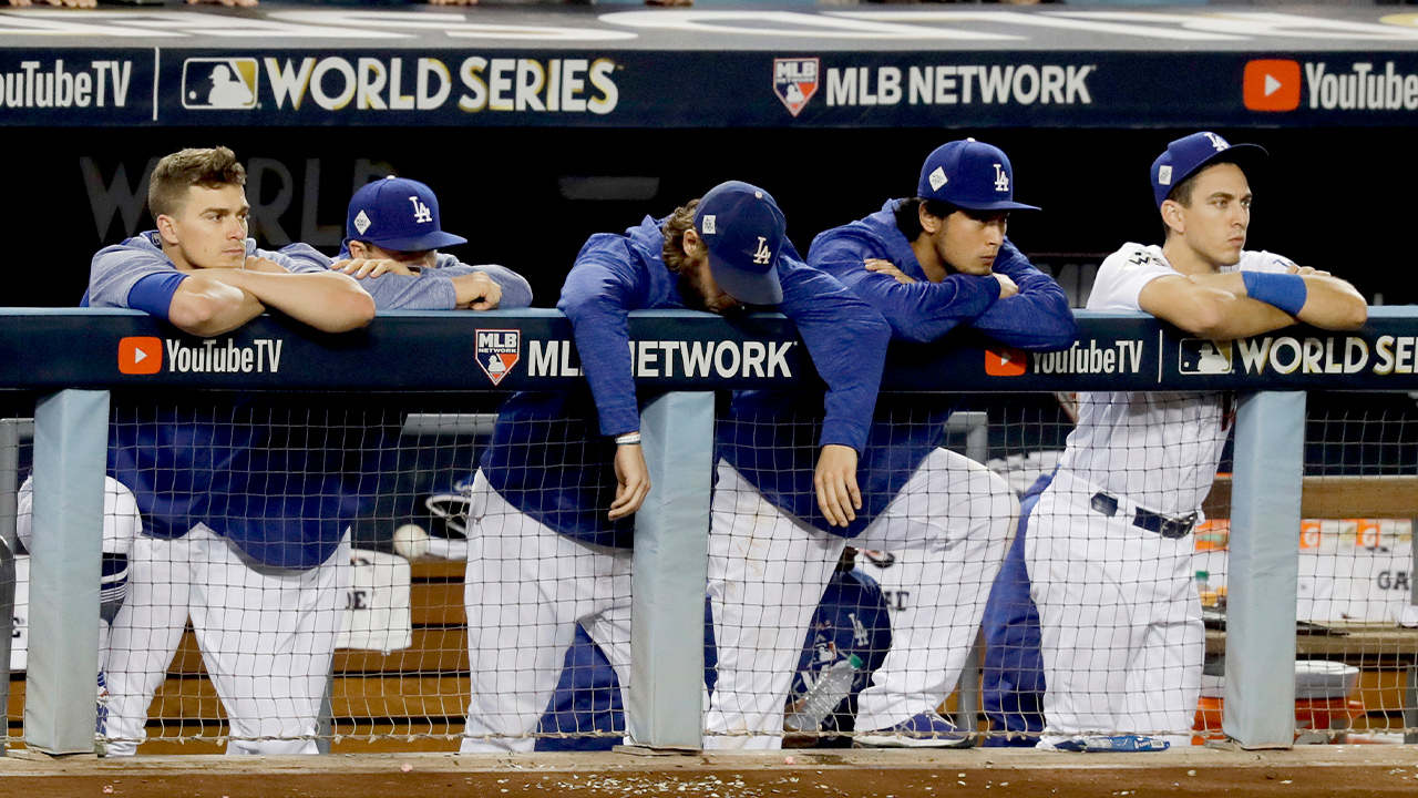 Photo of members of the Los Angeles Dodgers watching the Houston Astros celebrate their win in Game 7 of baseball's World Series in Los Angeles