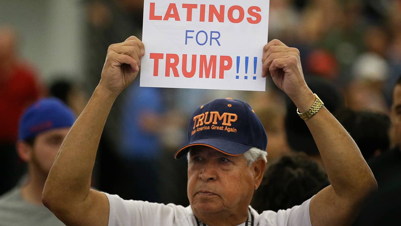 Photo of a man holding up a sign for President Donald Trump