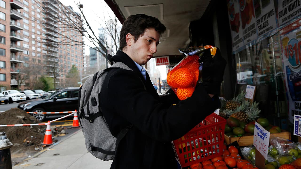 Photo of Liam Elkind looking at oranges