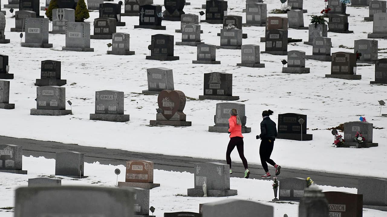 Photo of joggers running through a cemetery