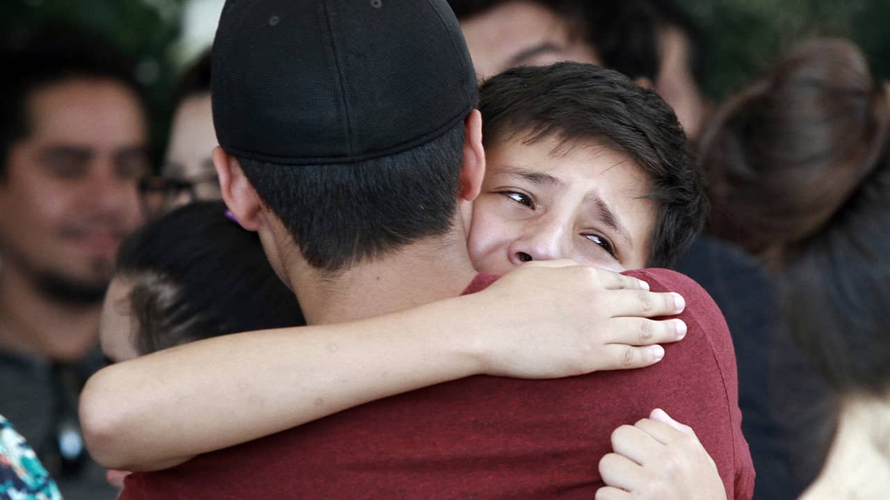 Photo of youths comforting each other at a funeral