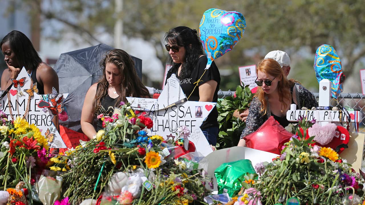 Photo of mourners paying tribute at a memorial for the victims of the shooting at Marjory Stoneman Douglas High School