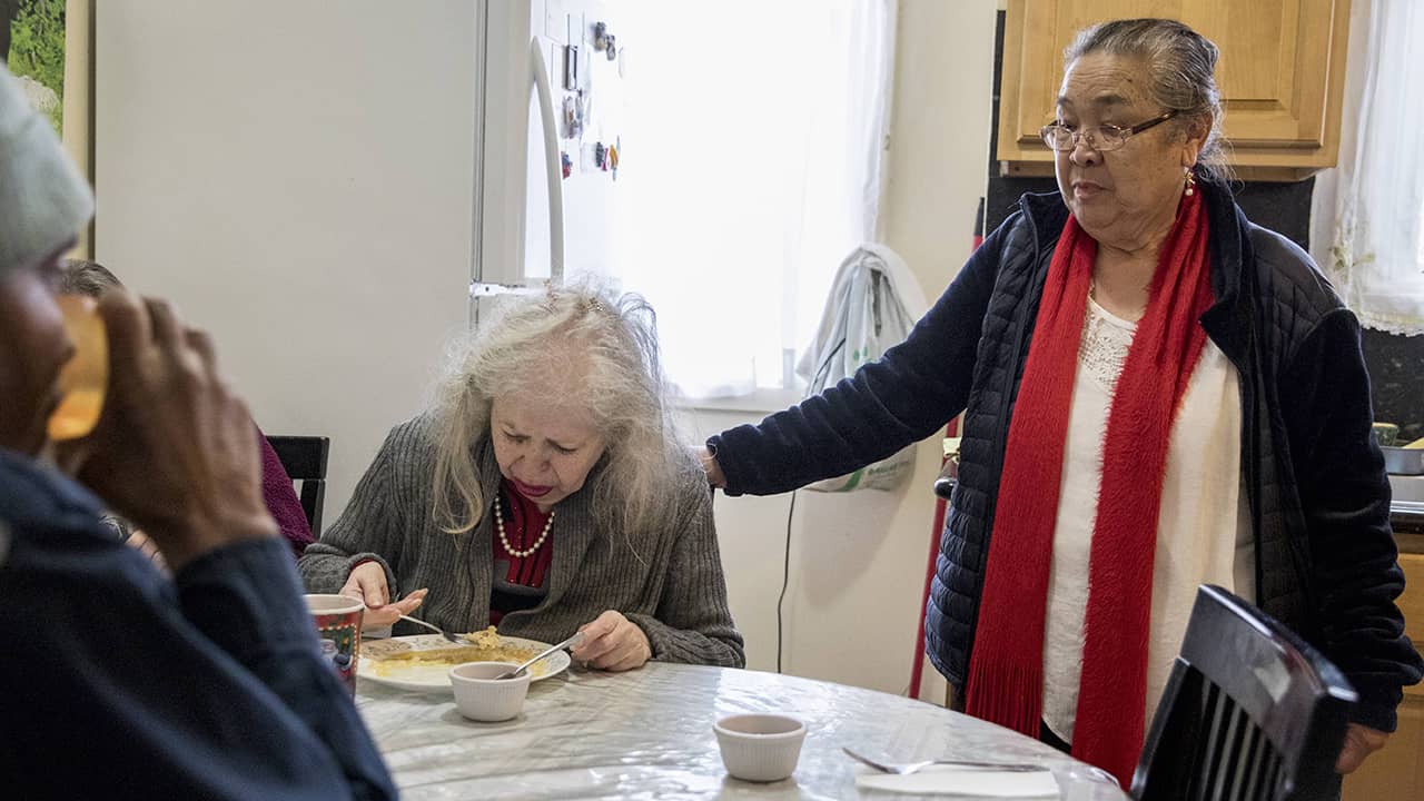 Photo of Carmen Palarca checking on a resident 