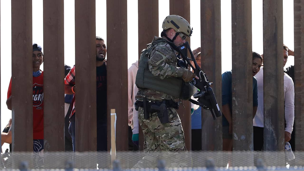 Photo of Border Protection officers walking along a wall at the border between Mexico and the U.S.