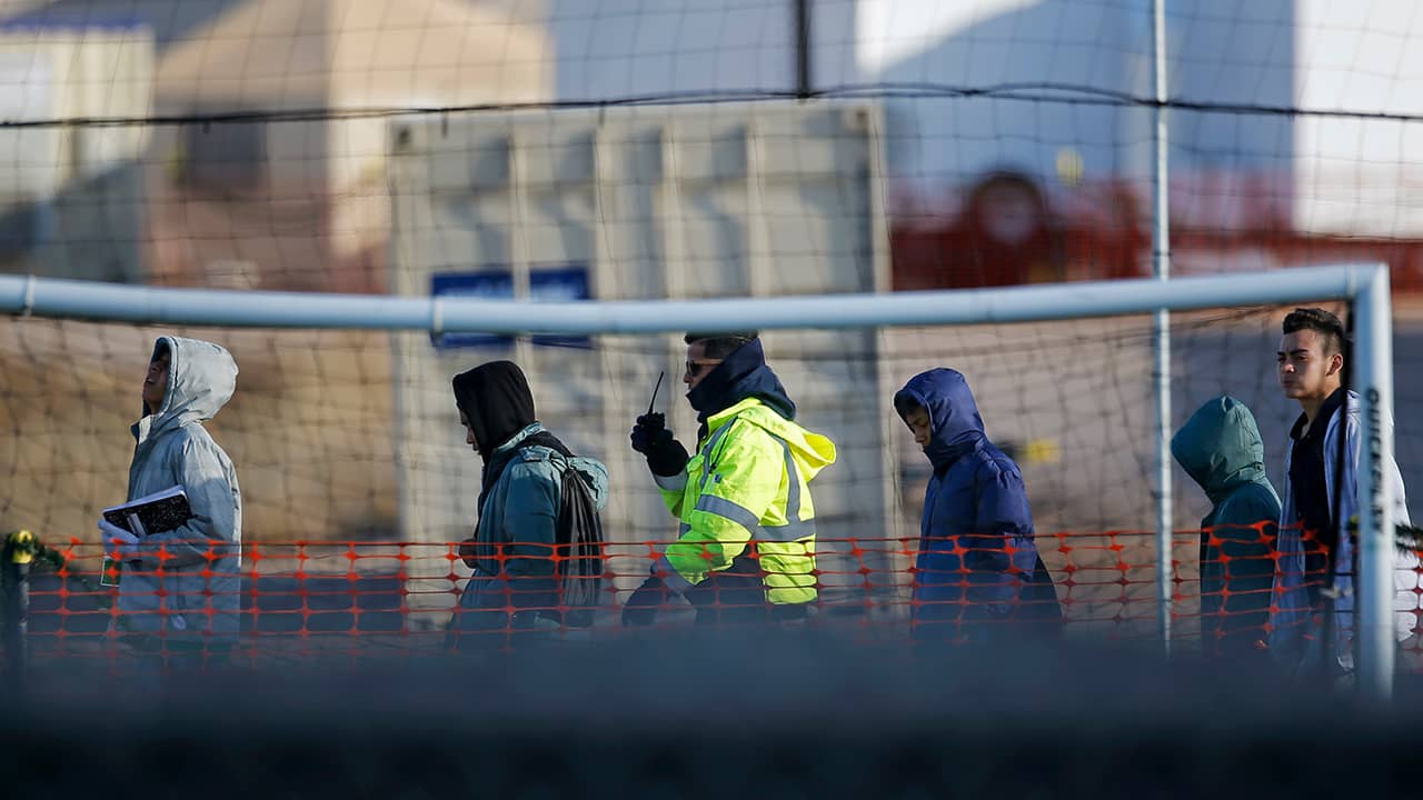 Photo of teen migrants walking in a line