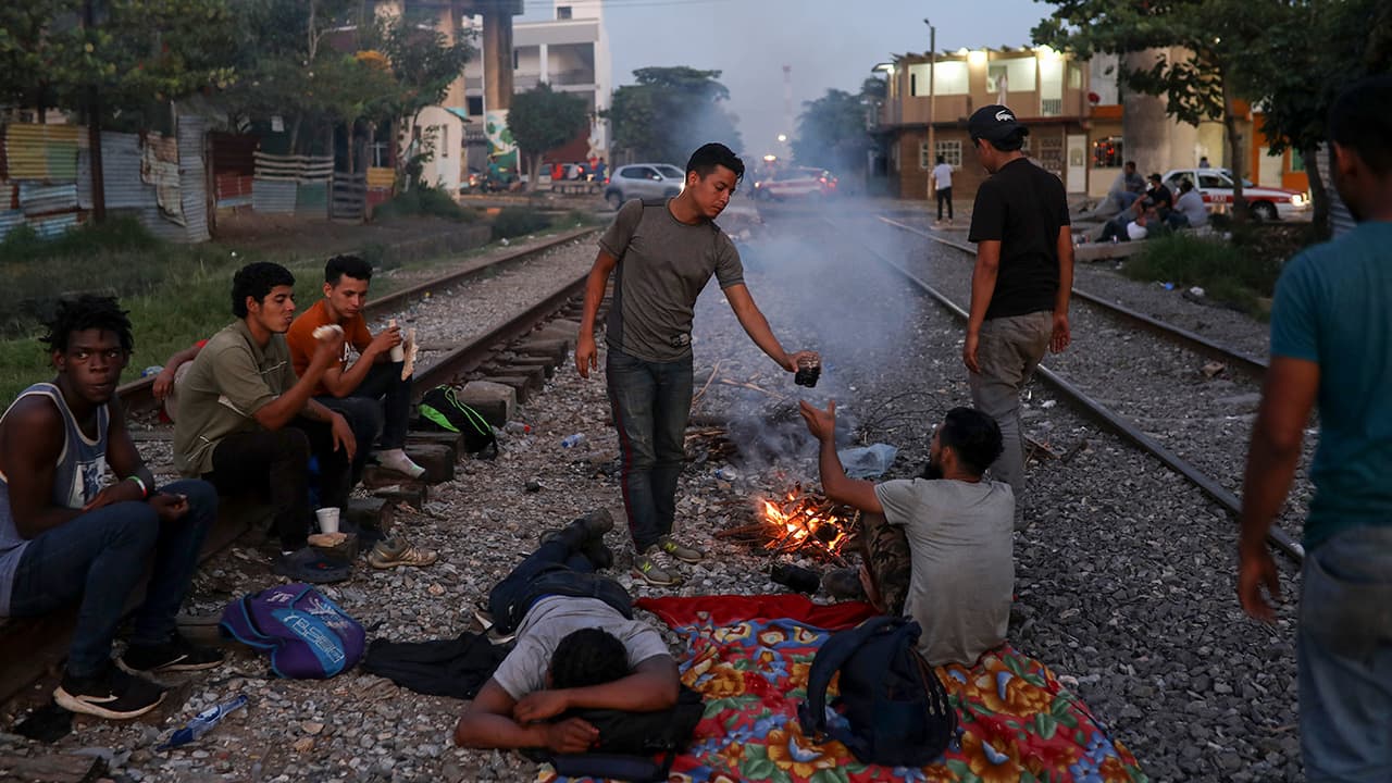 Photo of Central American migrants waiting to catch a ride on a train 