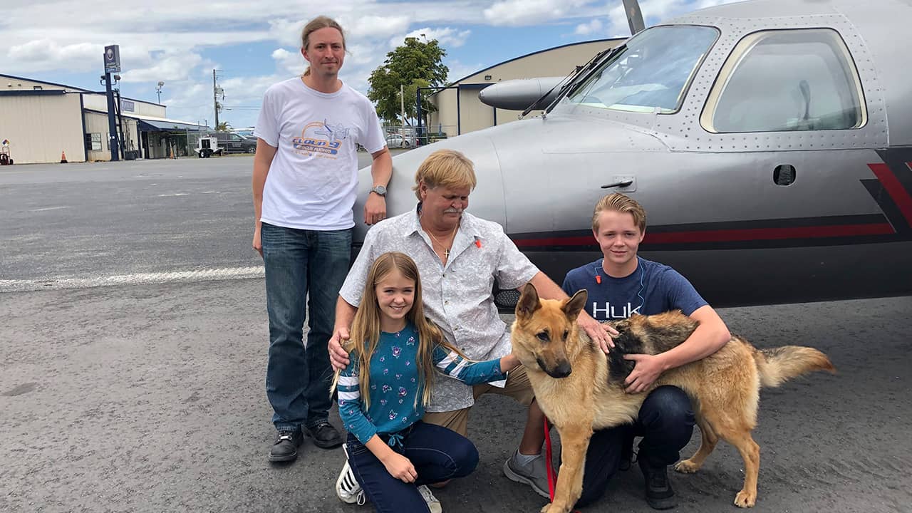 Photo of Chloe, Doug and Chase Peterson greeting their long-lost German Shepherd dog Cedar