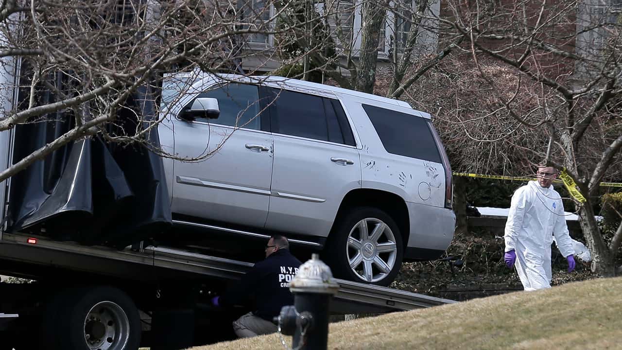 Photo of crime investigators loading a car