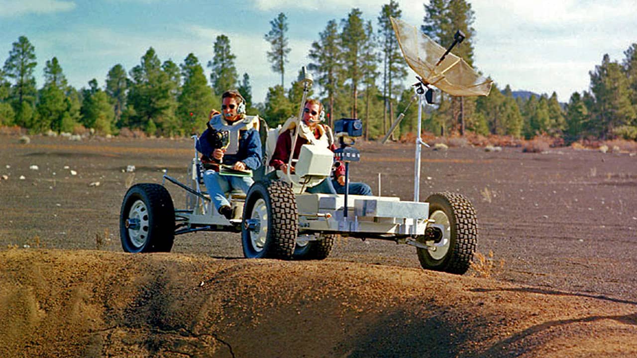 Photo of Apollo 15 astronauts, Jim Irwin and Dave Scott, driving a prototype of a lunar rover