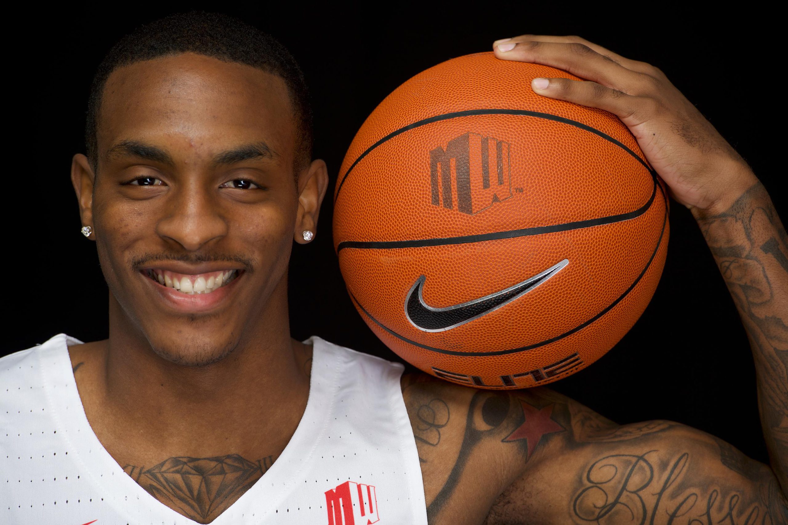 Photo of Deshon Taylor with a basketball on his shoulder