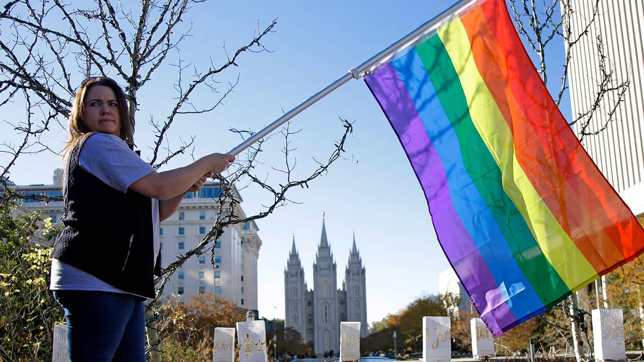 Photo of a woman holding a rainbow flag