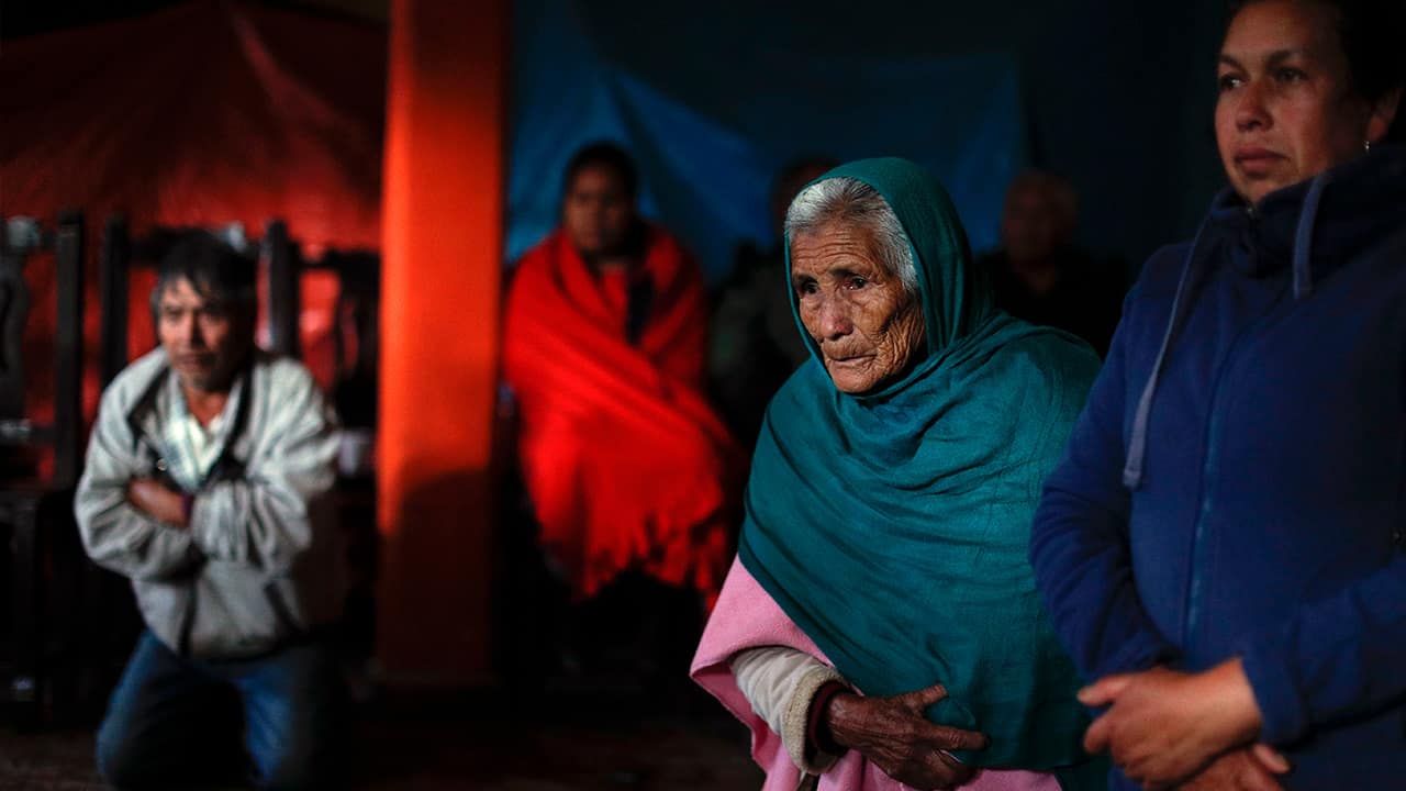 Photo of mourners praying on their knees around the coffin of environmental activist Homero Gomez Gonzalez