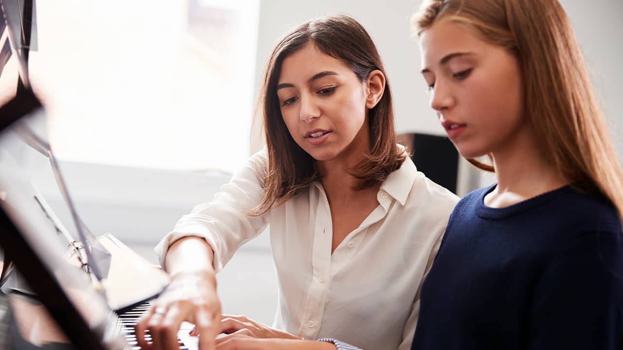 Photo of a student and teacher during a piano lesson