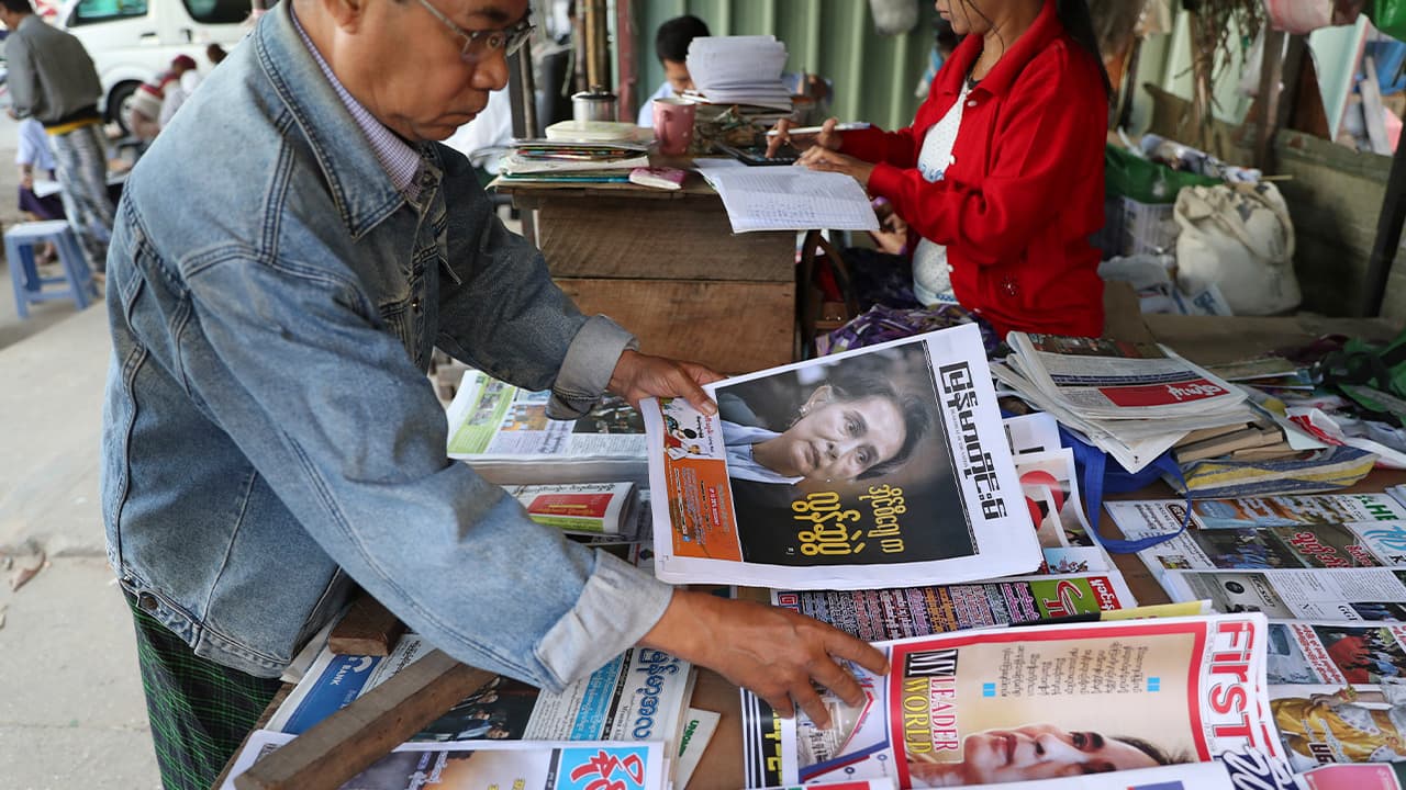 Photo of a man looking through newspapers