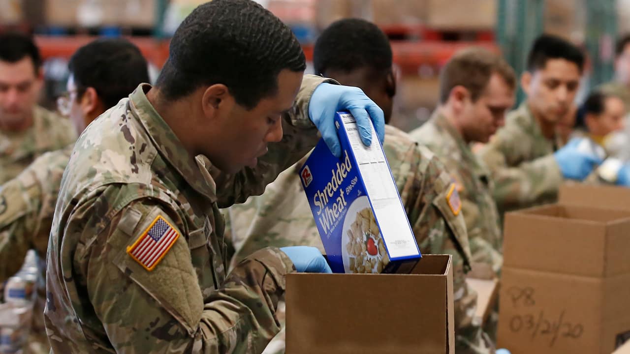 Photo of a National Guard member packing a box of supplies in Sacramento