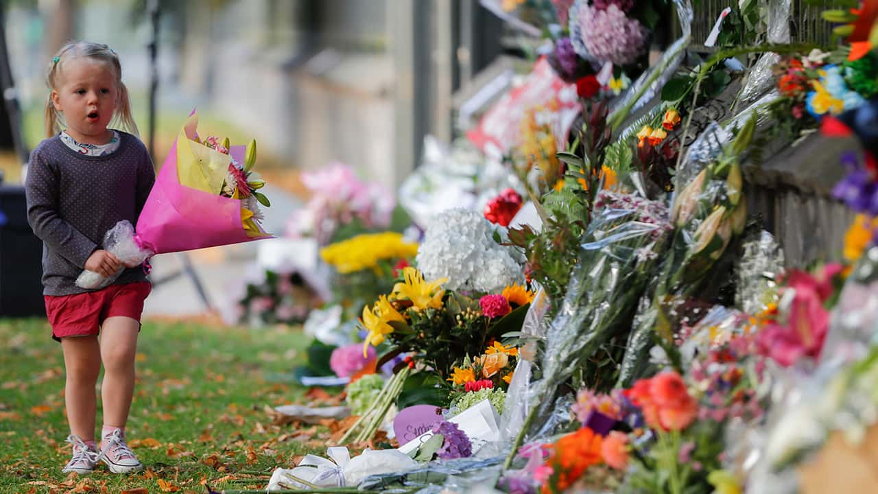 Photo of girl walking by flowers on a wall at the Botanical Gardens in New Zealand