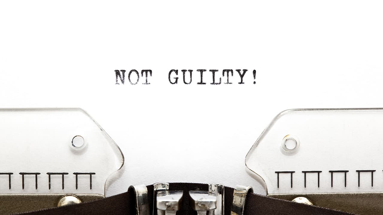 the words "Not Guilty!" on white paper in a typewriter