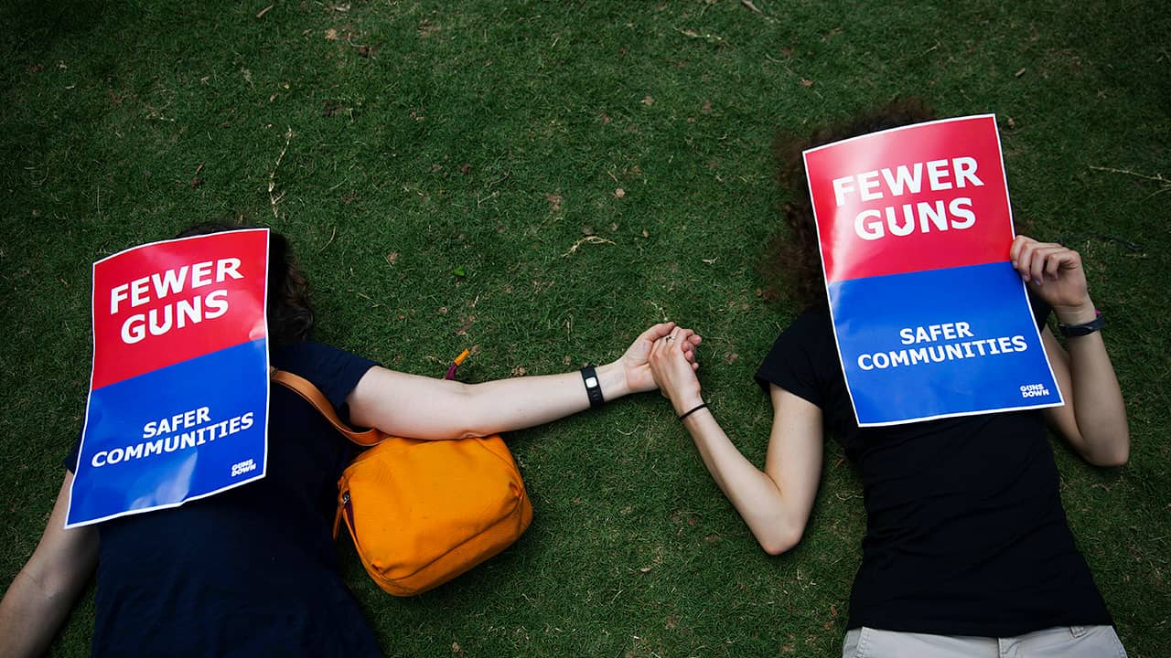 Photo of demonstrators holding hands at the NRA convention