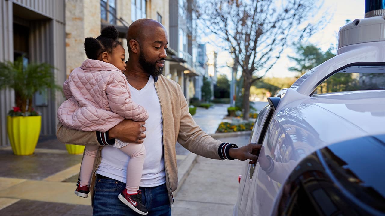 Photo of a man next to Nuro's self-driving vehicle "R2"