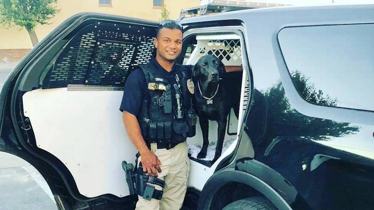 Photo of Newman, California, police officer Ronil Singh standing next to his patrol car