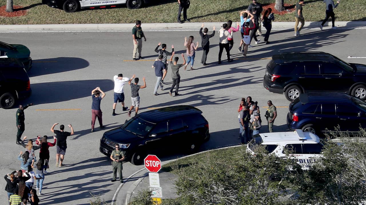 Photo of students holding their hands in the air as they are evacuated in Parkland, Fla.