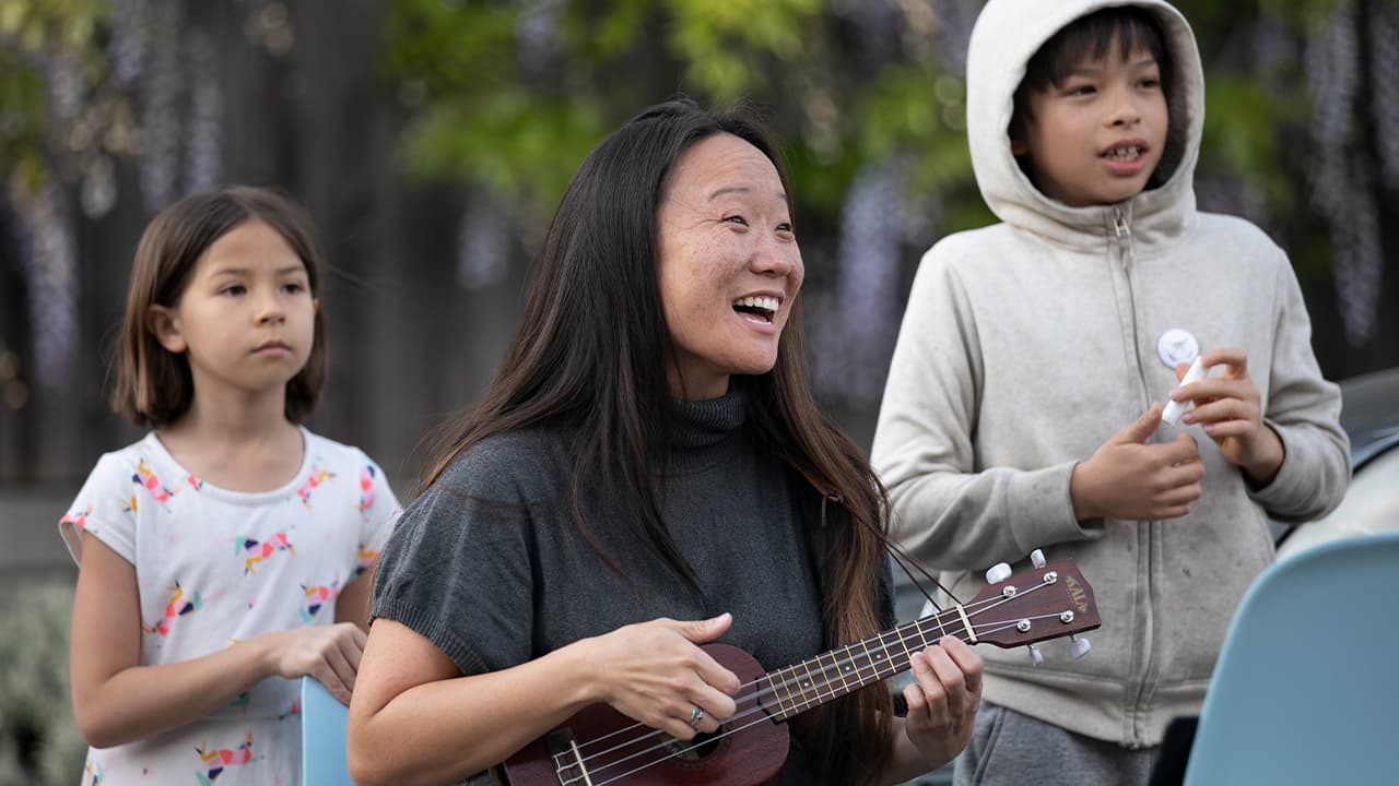 Photo of Patti Wang-Cross playing her ukulele 