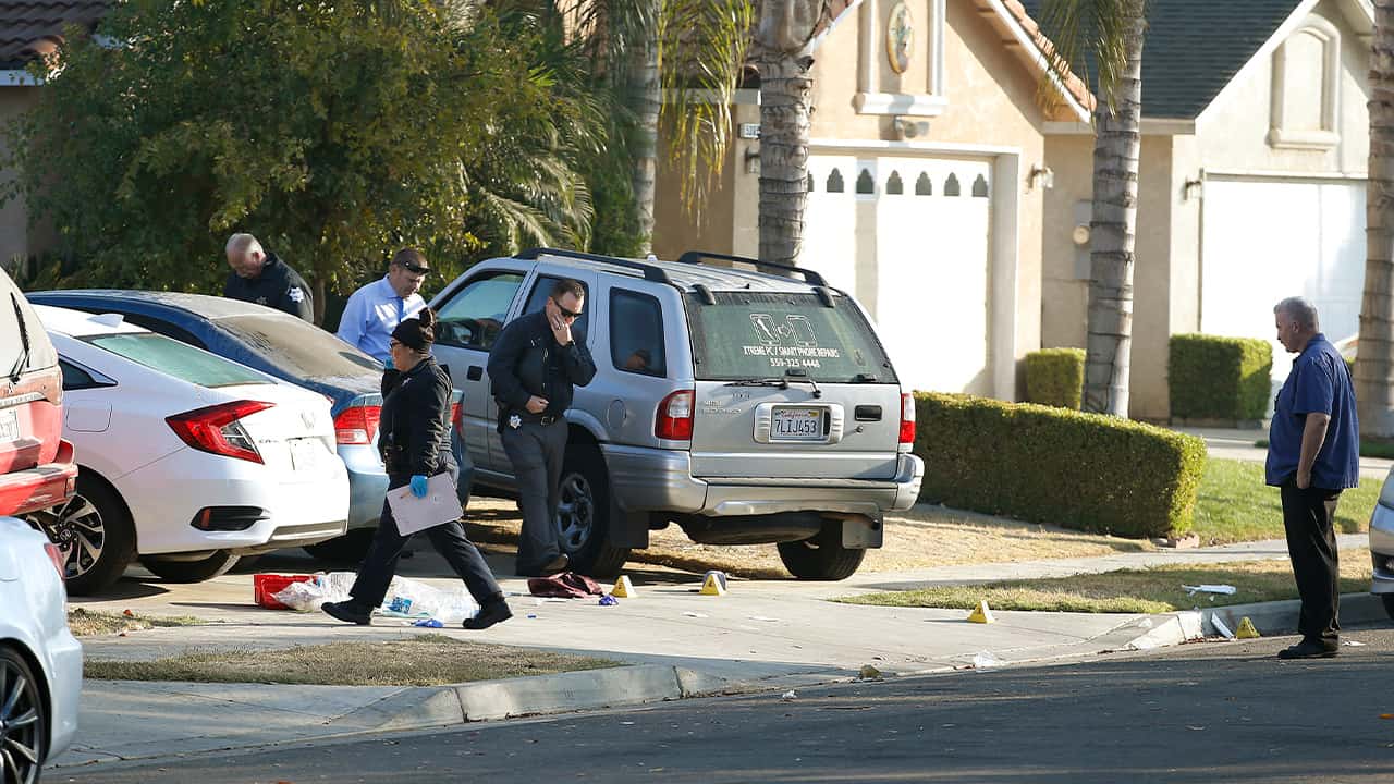Photo of Fresno police investigators working in the driveway