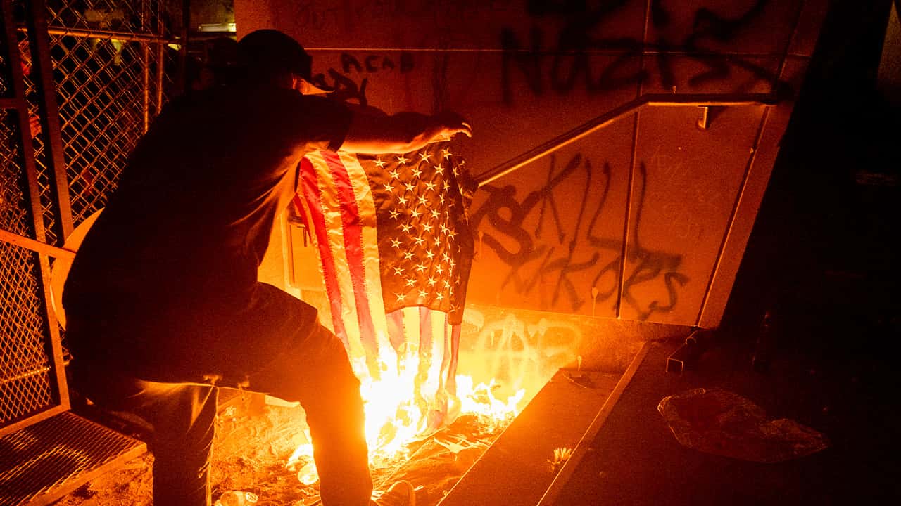 Photo of a protester burning a flag