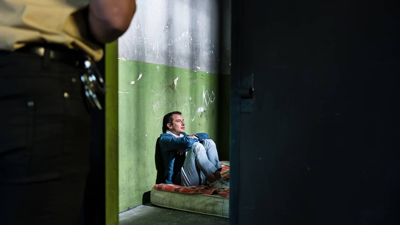 Photo of a prisoner sitting on a mattress