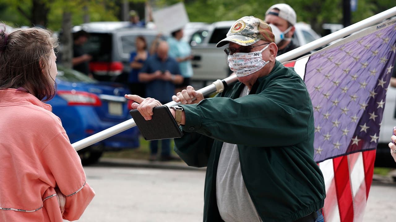 Photo of a man and a counter-protester as people with ReopenNC gather in Raleigh, N.C.