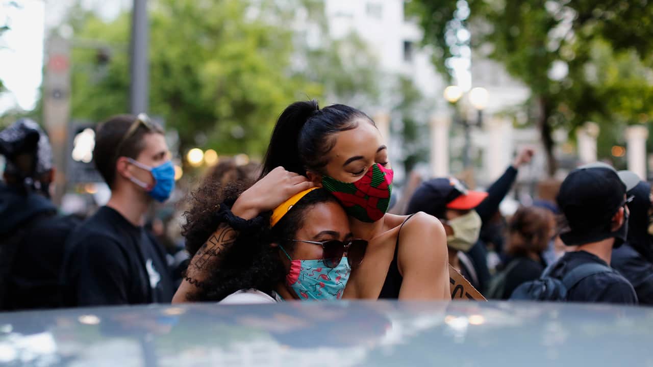 Photo of protesters hugging in Portland 