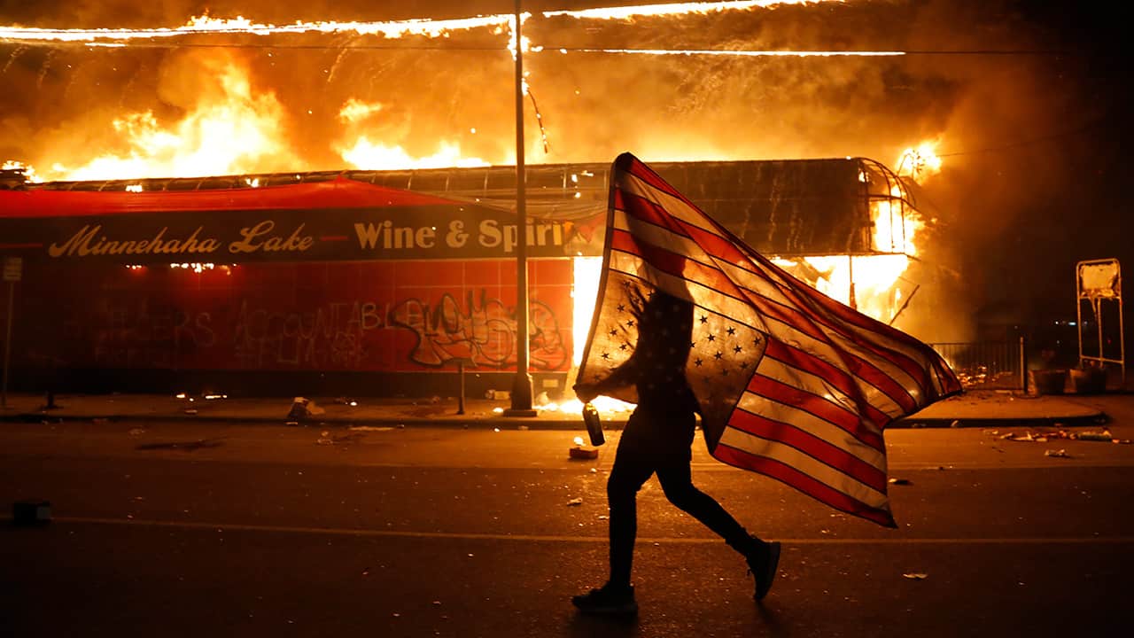 Photo of a protester carrying a flag upside down