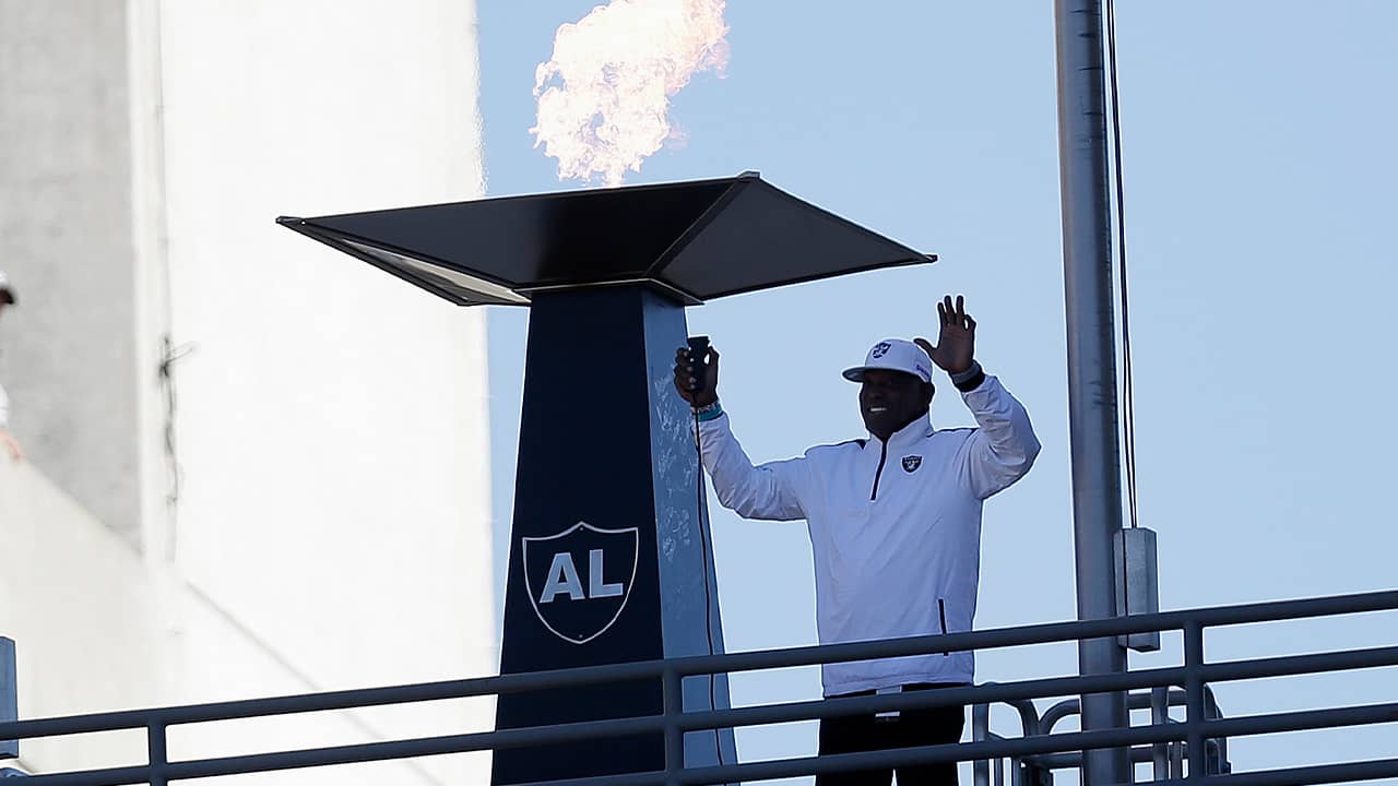 Photo of Cliff Branch lighting a memorial flame in honor of Al Davis.