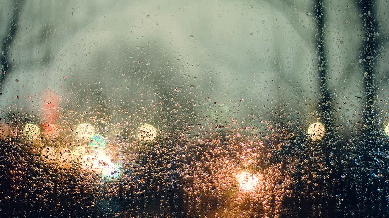 photo of rain and lights seen through a window