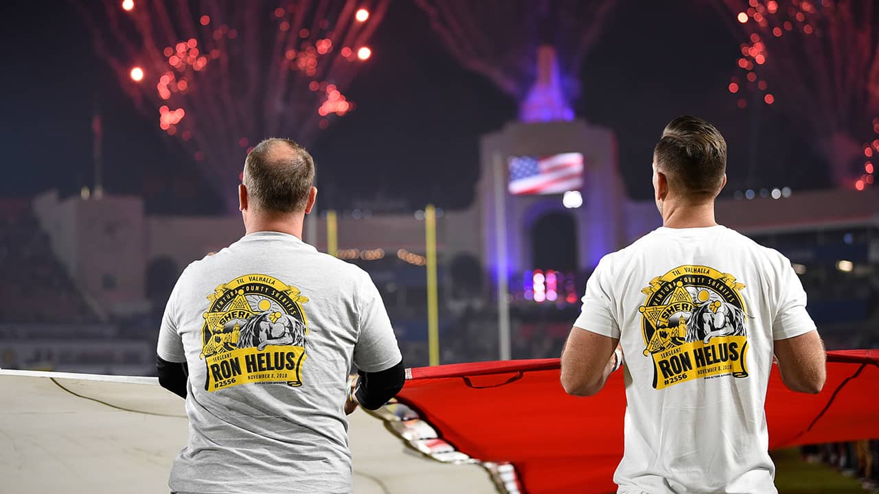 Photo of first responders holding the flag at the Los Angeles Rams game