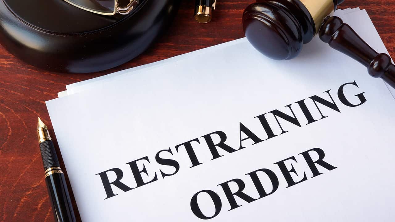 Photo of a restraining order on a desk with a gavel